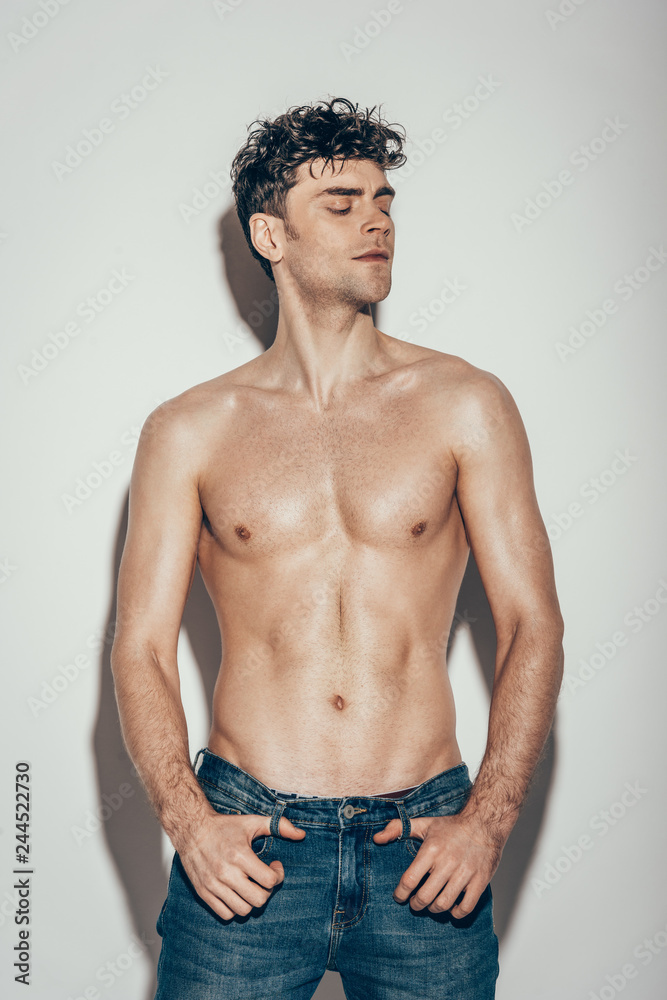 Fototapeta premium sexy shirtless fashionable man in jeans posing on grey
