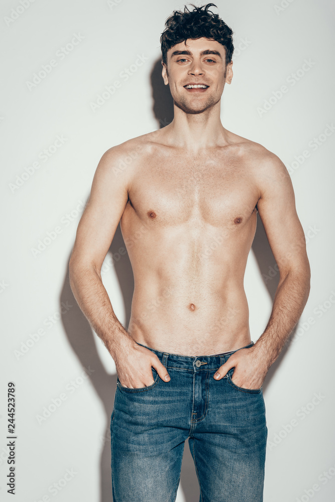 Fototapeta premium sexy shirtless stylish man in jeans posing on grey