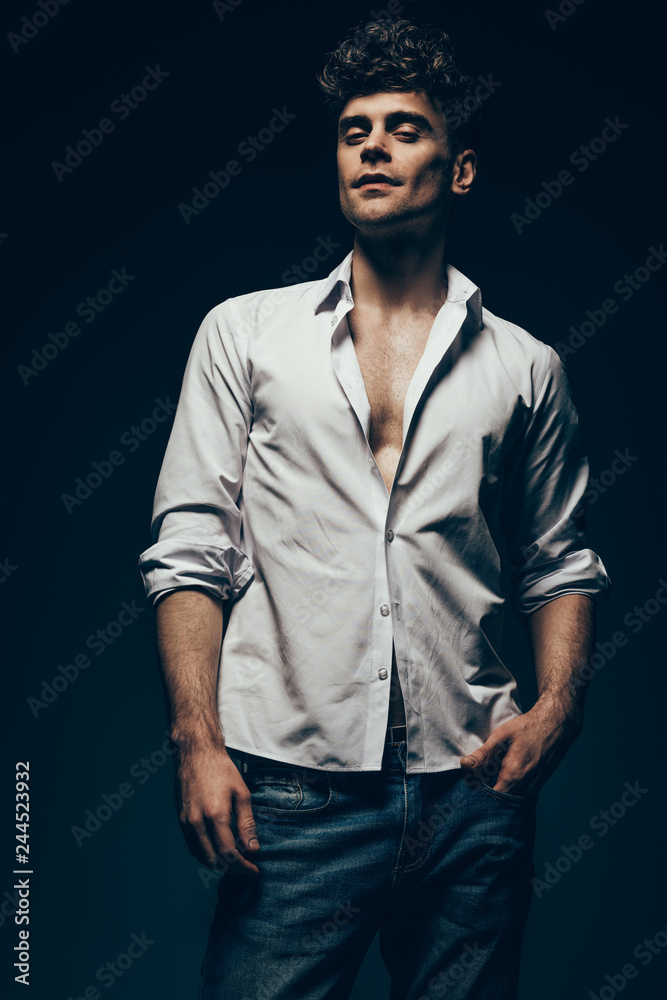 fashionable sexy man posing in white shirt isolated on dark grey fashionable sexy man posing in white shirt isolated on dark grey