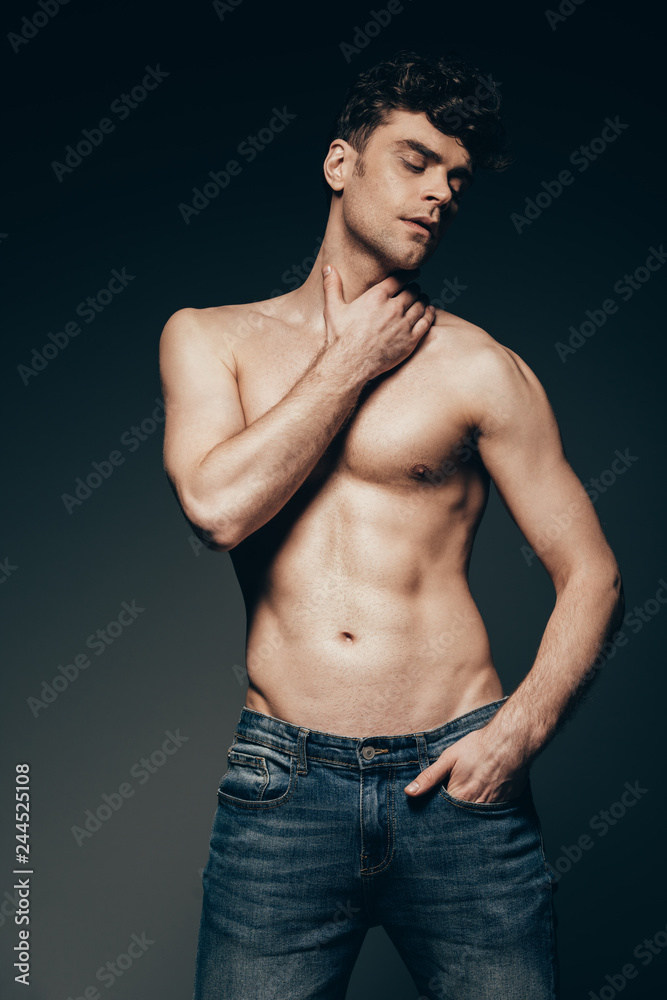 sexy shirtless man in jeans posing isolated on dark grey sexy shirtless man in jeans posing isolated on dark grey