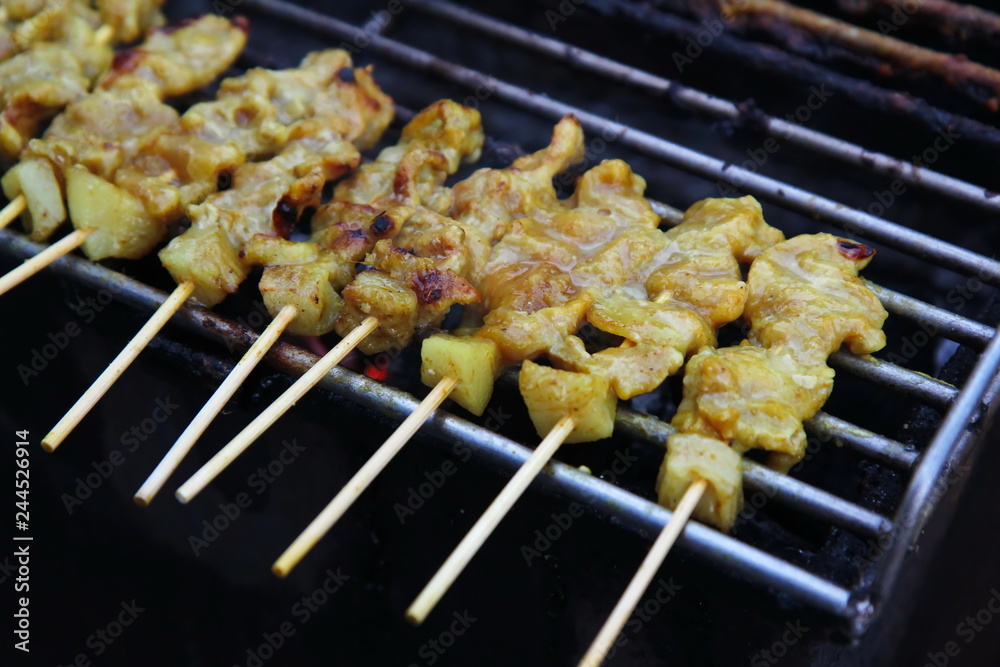 Grillled barbecue pork satay skewers on charcoal grill stove in street food market. Pork. Grilled spices pork on Charcoal stove Grillled barbecue pork satay skewers on charcoal grill stove in street food market. Pork. Grilled spices pork on Charcoal stove