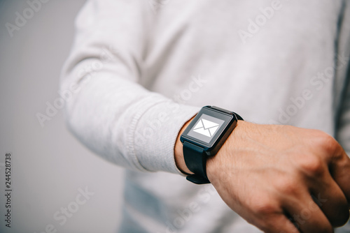 cropped view of man with smartwatch with email icon