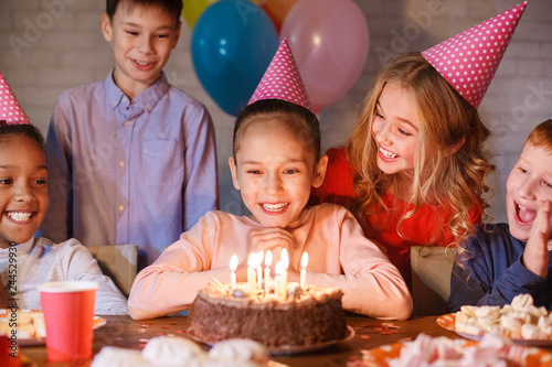 Girl looking at birthday cake with candles