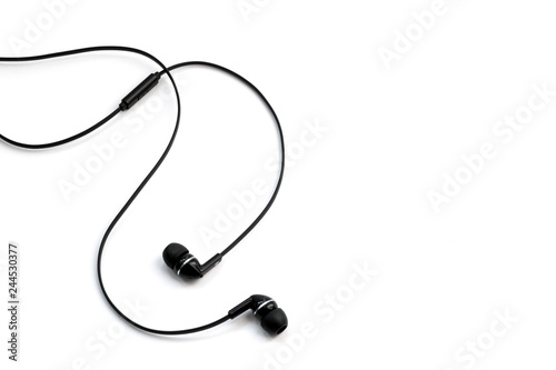 Earphones headset. In-ear headphones. Vacuum wired black headphones for listening to music and sound on portable devices: music player, smartphone, laptop on a white background. Ear plugs. © Andrii A