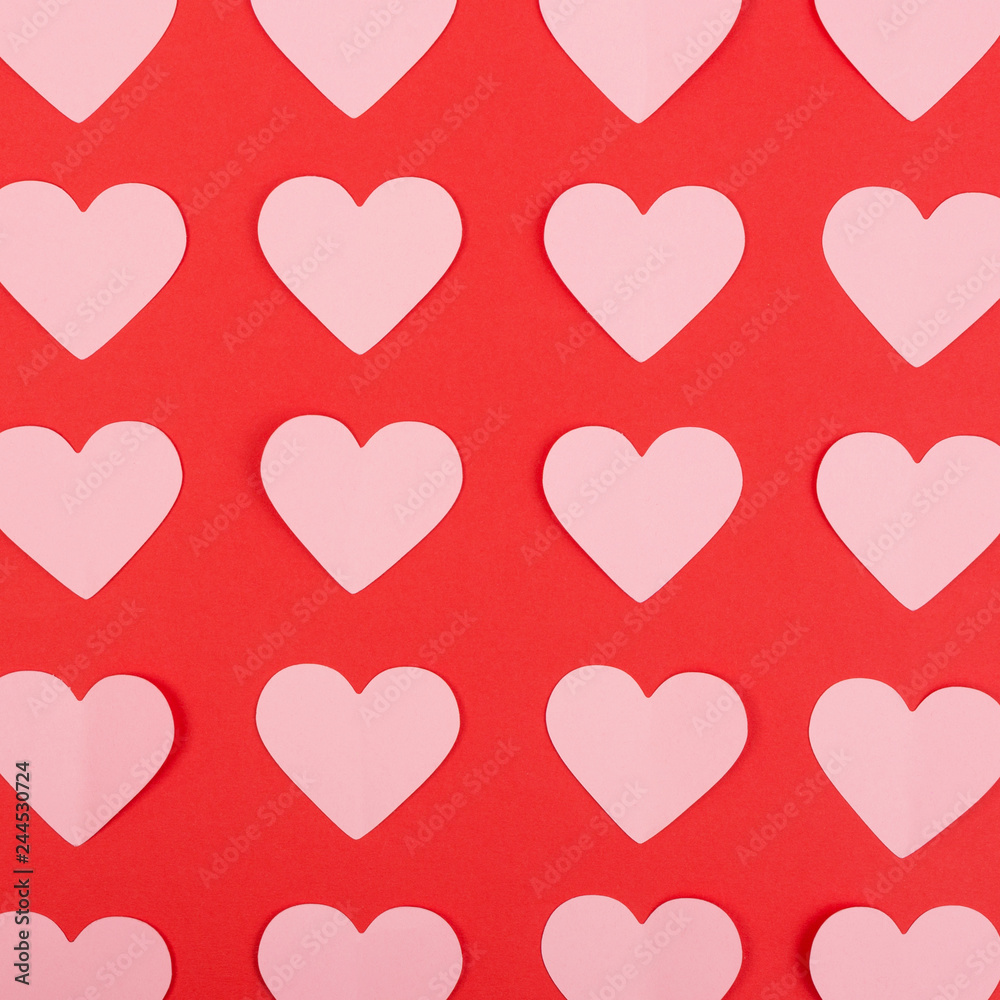 Pink paper hearts arranged in rows on red background. Flat lay. Crop image