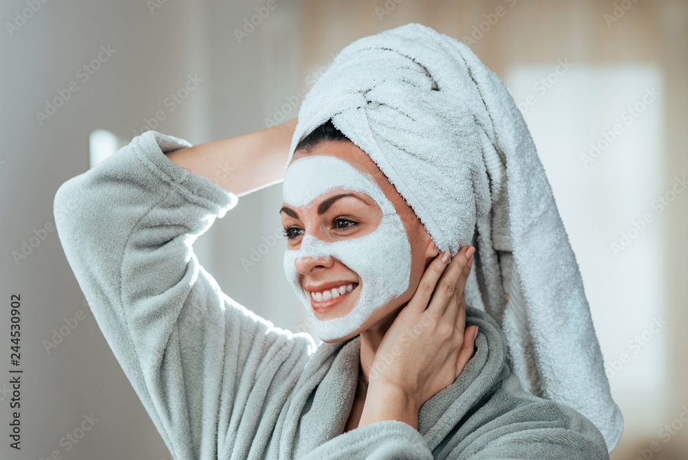Portrait of a beautiful smiling woman with face mask and a towel. Portrait of a beautiful smiling woman with face mask and a towel.