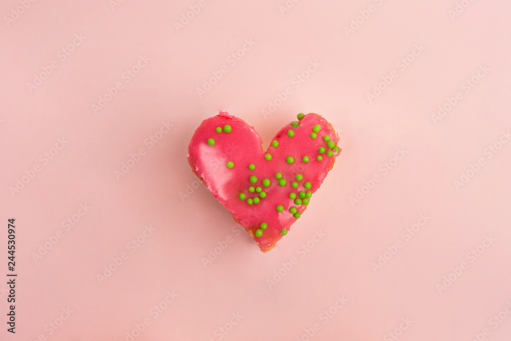 Heart shaped strawberry cake with green decoration on pink background. Heart cake for Valentine's Day