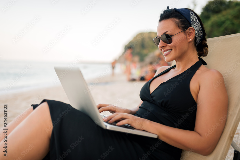 Young female freelancer working on the beach.