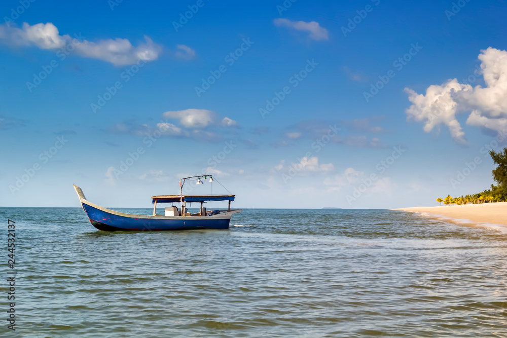 Traditional Asian wooden boat moves across the sea against a blue sky with clouds. Copy space