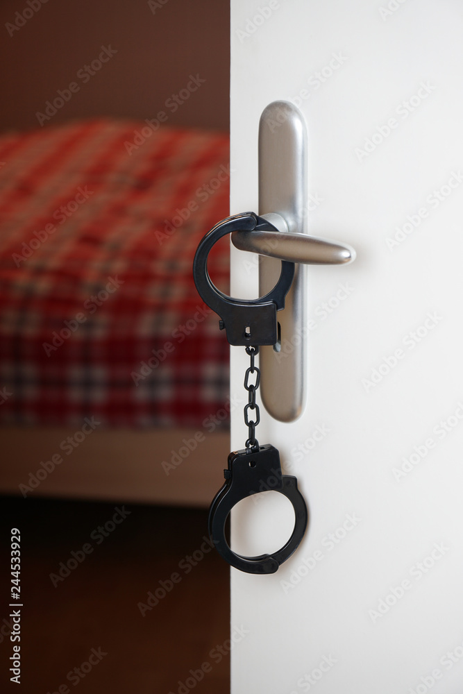 handcuffs are hanging from bedroom door handle                               