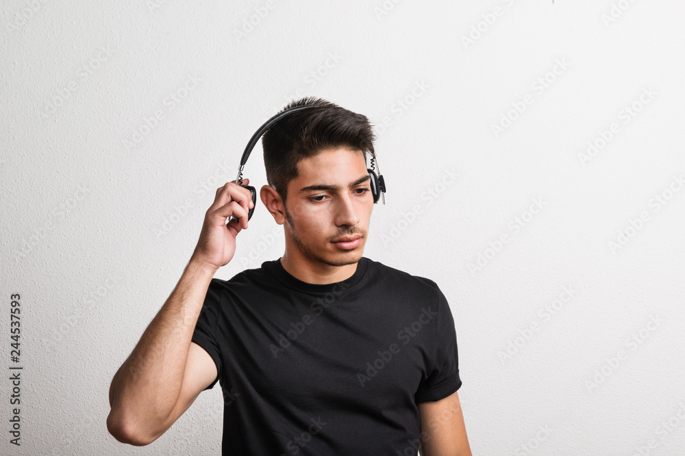 Portrait of a joyful young hispanic man with headphones in a studio. Copy space. Portrait of a joyful young hispanic man with headphones in a studio. Copy space.