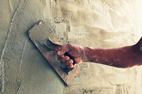 construction worker plastering cement on wall photo