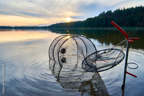 Fototapeta Naklejka Na Ścianę i Meble -  Beautiful view of the sunset with net for fish over Lemiet lake in Mazury district, Poland. Fantastic travel destination.