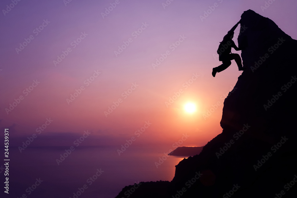 Silhouette purple of man climbing rock, Photographer on the mountain at sunrise