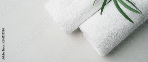 Obraz na plátně Spa concept: two white fluffy towels twisted into rolls on a light surface with