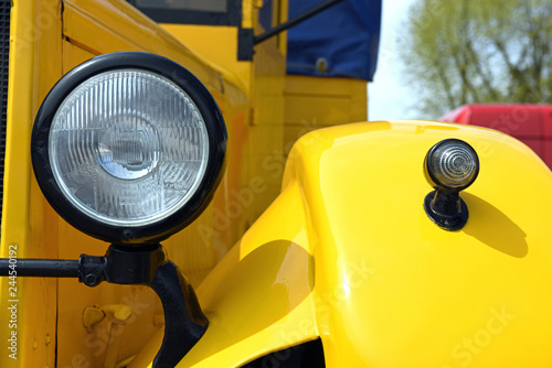 Large round headlight on an old retro car, close-up.