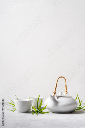 Asian food background set with  green tea, cups and teapot with free space for text on white background.