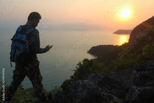 Silhouette of man climbing rock, Photographer on the mountain at sunrise