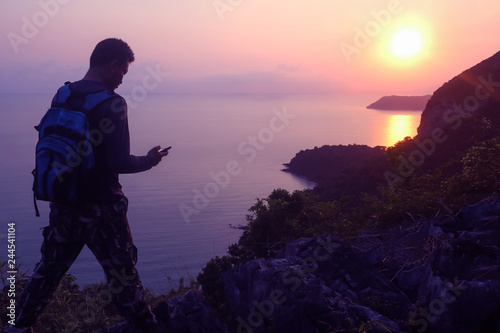 Silhouette purple of man climbing rock  Photographer on the mountain at sunrise