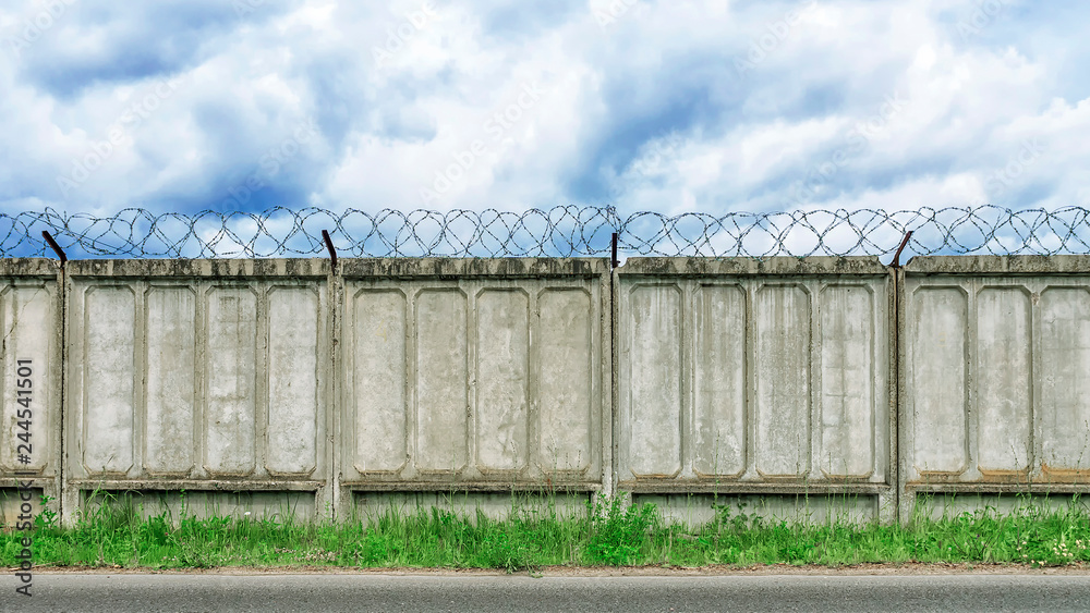 concrete fence with barbed wire