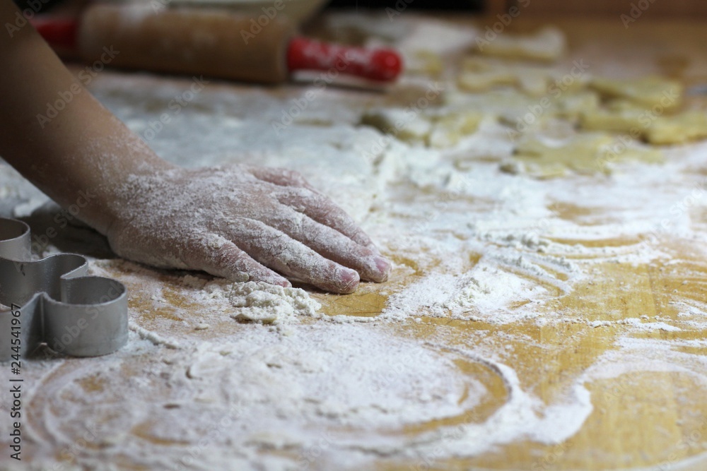 Cooking on kitchen. Having fun together while making cakes and cookies. Child rolling out dough for christmas cookies. Cooking on kitchen. Having fun together while making cakes and cookies. Child rolling out dough for christmas cookies.