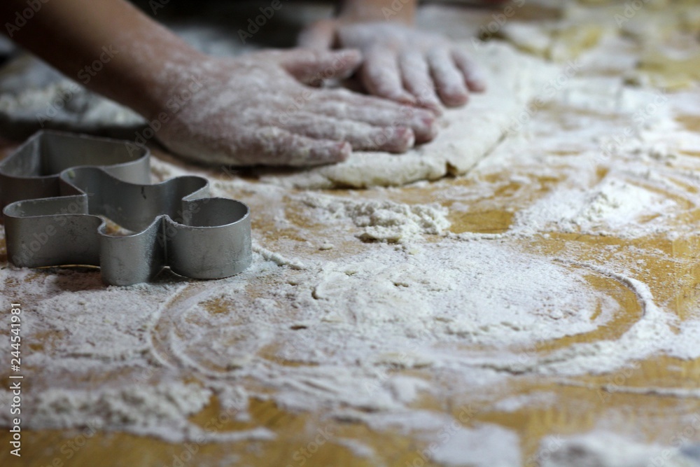 Fototapeta premium Cooking on kitchen. Having fun together while making cakes and cookies. Child rolling out dough for christmas cookies.