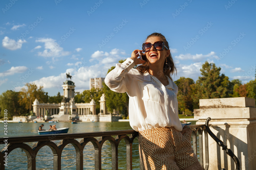 Fototapeta premium kobieta w Parque del Buen Retiro rozmawia przez telefon komórkowy