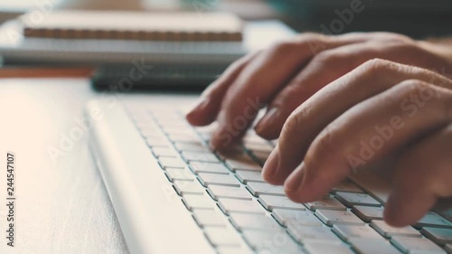 Male hands typing on the wireless keyboard. Workplace of businessman in the office. Close view and very smooth dolly shot 4K video
