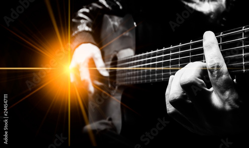 closeup male artist hands playing acoustic guitar on stage with concert light