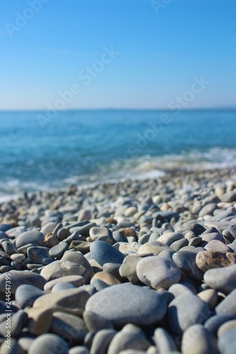 Grey stones on a blue sea under a blue sky