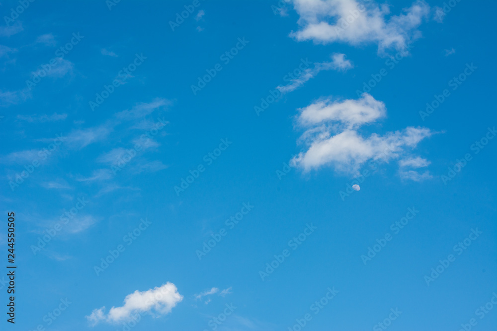 Moon on the daylight blue sky with clouds Moon on the daylight blue sky with clouds