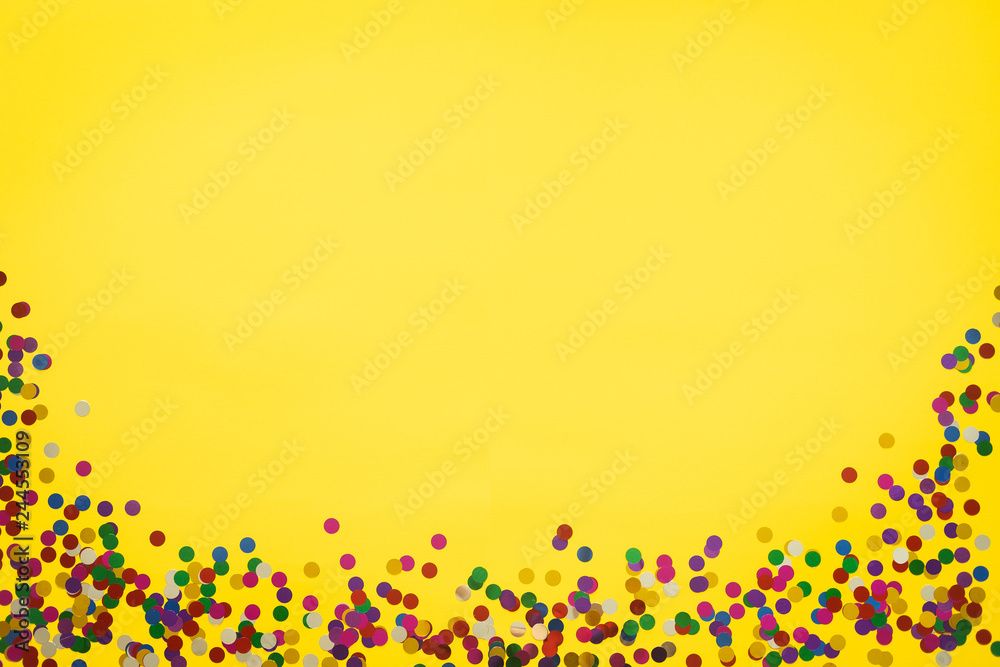 Birthday or party background. Festive greeting card. Yellow background with color confetti. Copy space