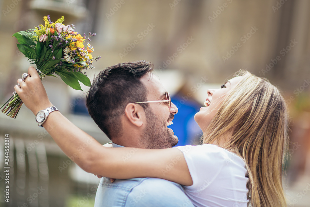 Picture of young man surprising woman with flowers