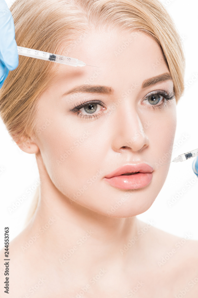 cropped shot of cosmetologist making beauty injections to attractive young woman isolated on white