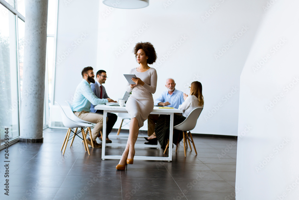 Fototapeta premium Smiling African woman using a tablet in office