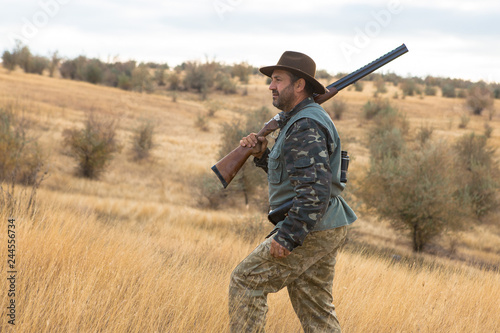 Hunter with a hat and a gun in search of prey in the steppe  © Mountains Hunter