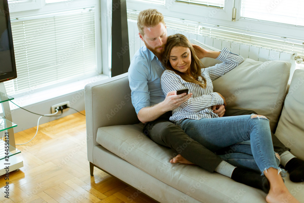 Loving couple in the room with mobile phone Loving couple in the room with mobile phone