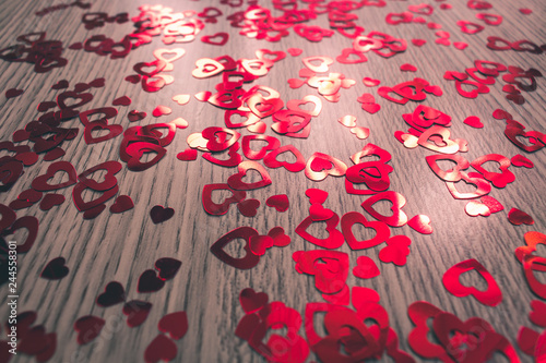Many red hearts of different sizes of Valentine's day on a wooden background