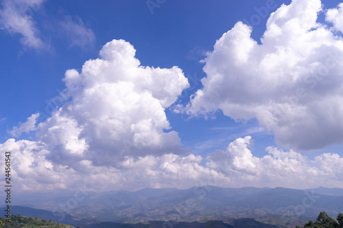 Fototapeta Naklejka Na Ścianę i Meble -  fluffy dramatic white cloud on blue sky over green mountain