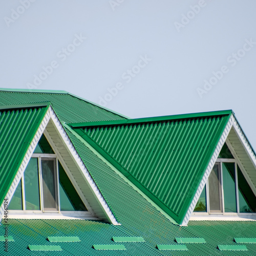 The house with plastic windows and a green roof of corrugated sh