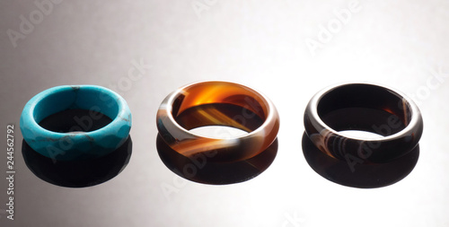 Three rings of blue, amber and black on a gray background with a gradient
