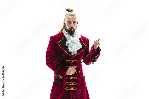 The young man wearing a traditional medieval costume of marquis posing at studio with whip. Fantasy, Antique, Renaissance concept