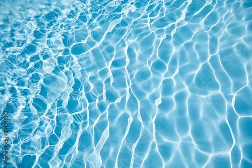 water surface in swimming pool with sun reflection, ripple, abstract background