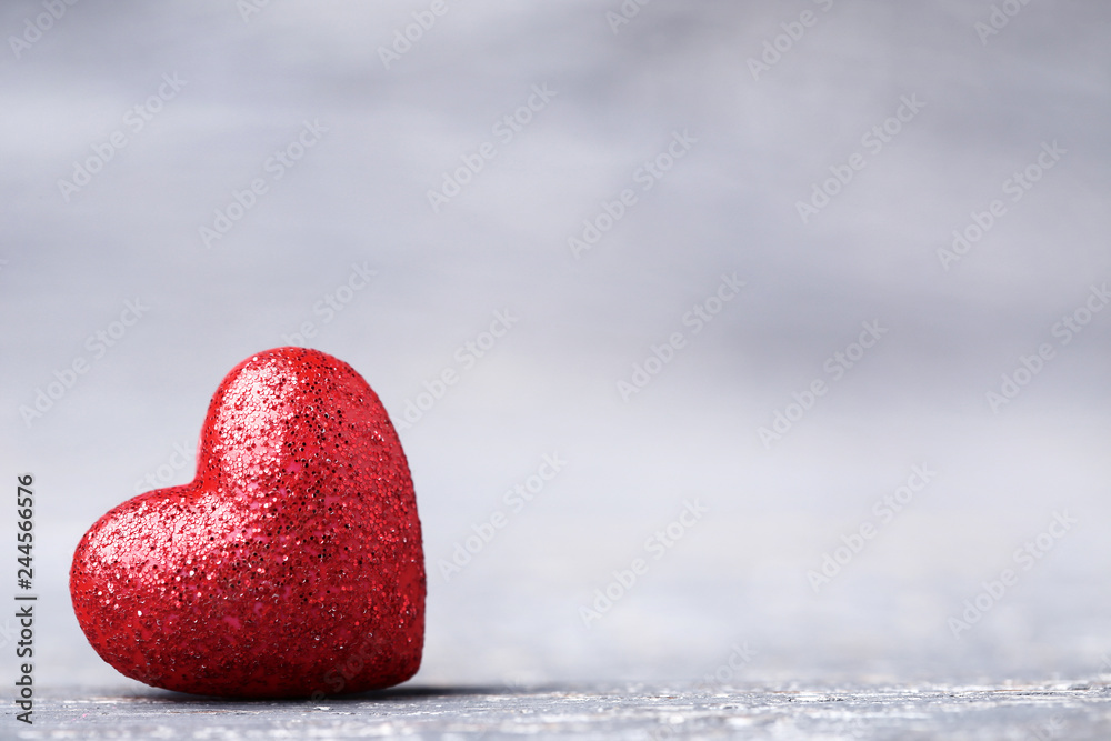 Fototapeta premium Red glitter heart on grey wooden table