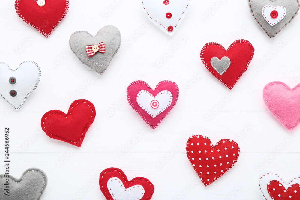 Colorful fabric hearts on white wooden table Colorful fabric hearts on white wooden table