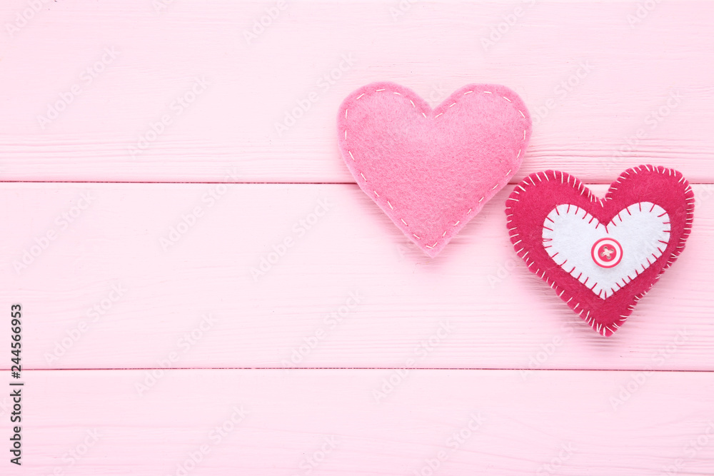 Fototapeta premium Fabric hearts on pink wooden table