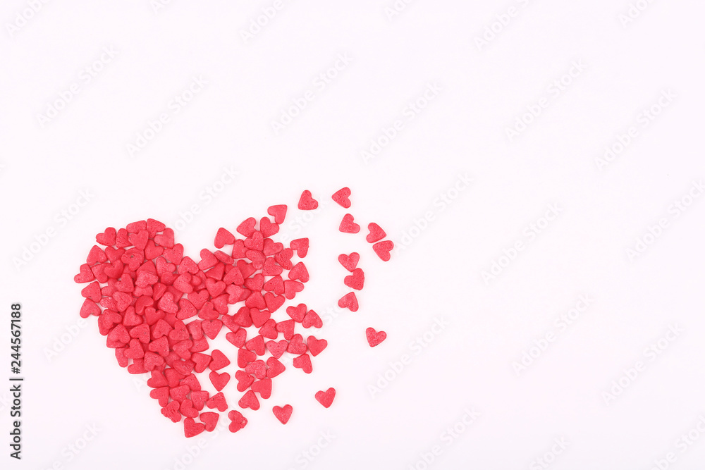 Pink heart shaped sprinkles on white background