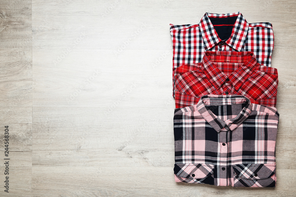Folded shirts on wooden table Folded shirts on wooden table