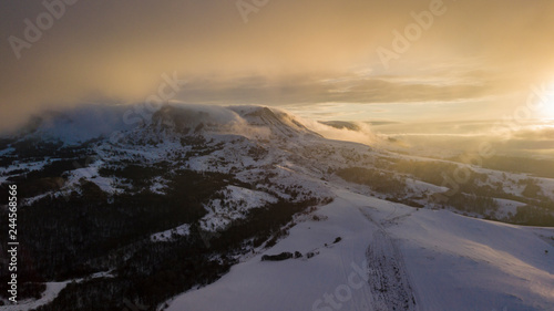 Aerial view of snow capped mountains during sunrise