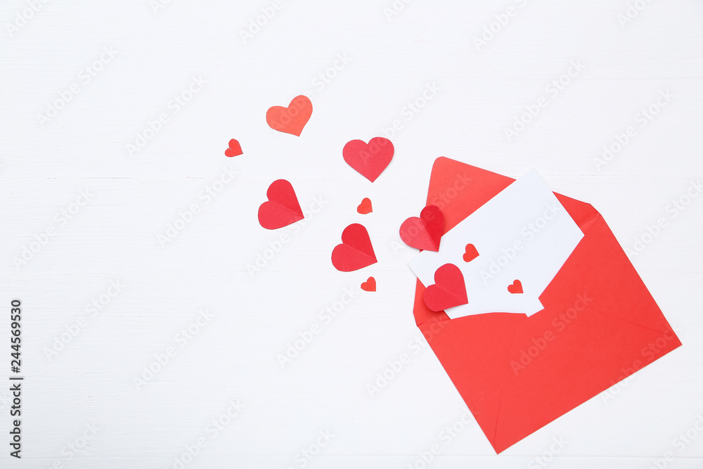 Red paper hearts with envelope on white background